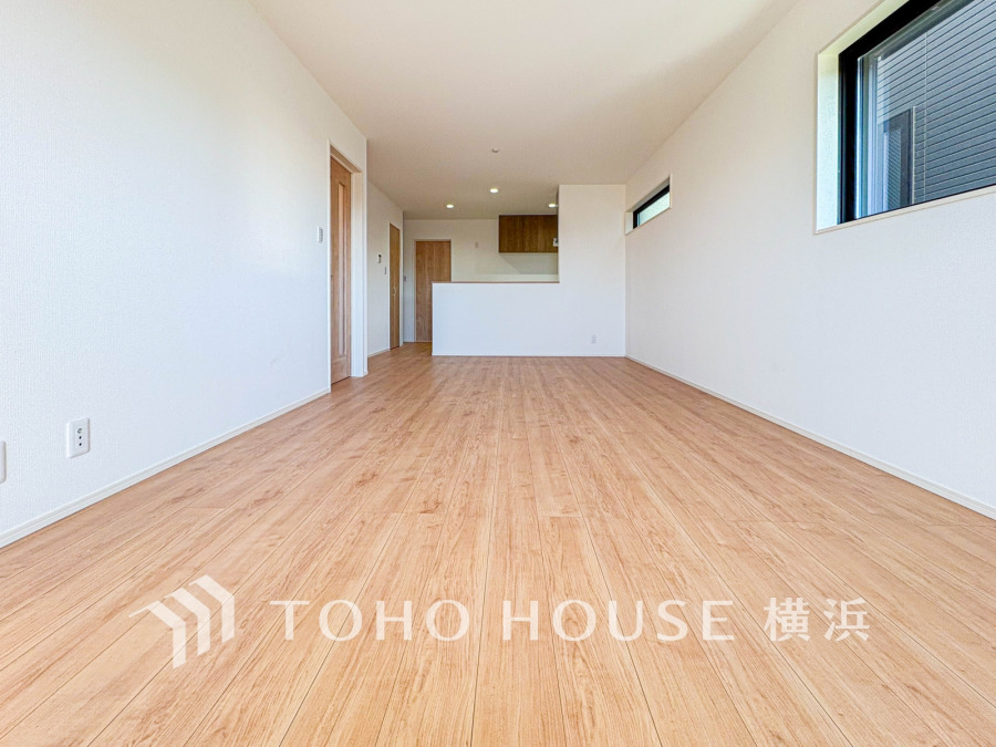 明るい自然光が差し込む、木目調フローリングの広々としたリビングダイニング空間です。