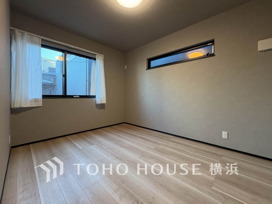 落ち着いた色合いの壁と木目調フローリングが調和した、明るく風通しの良いシンプルな洋室です。