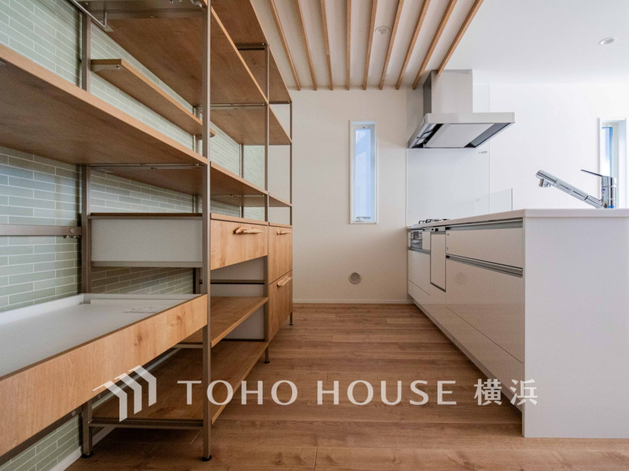 ナチュラルな木目と白を基調にした、機能的で開放感のあるキッチンスペースです。カップボードも標準装備。