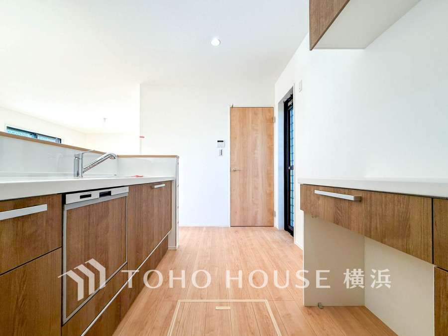 木目調の収納と白を基調とした清潔感あふれるキッチン。収納力と使いやすさを両立した設計です。