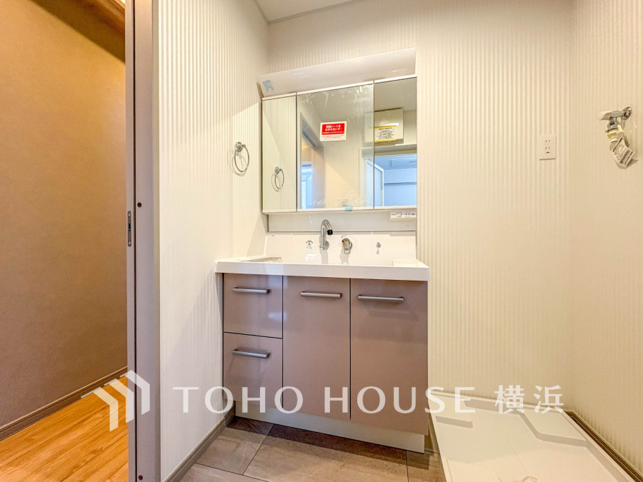 収納充実の洗面台と洗濯機置き場を備えた、清潔感あふれる機能的なサニタリースペースです。