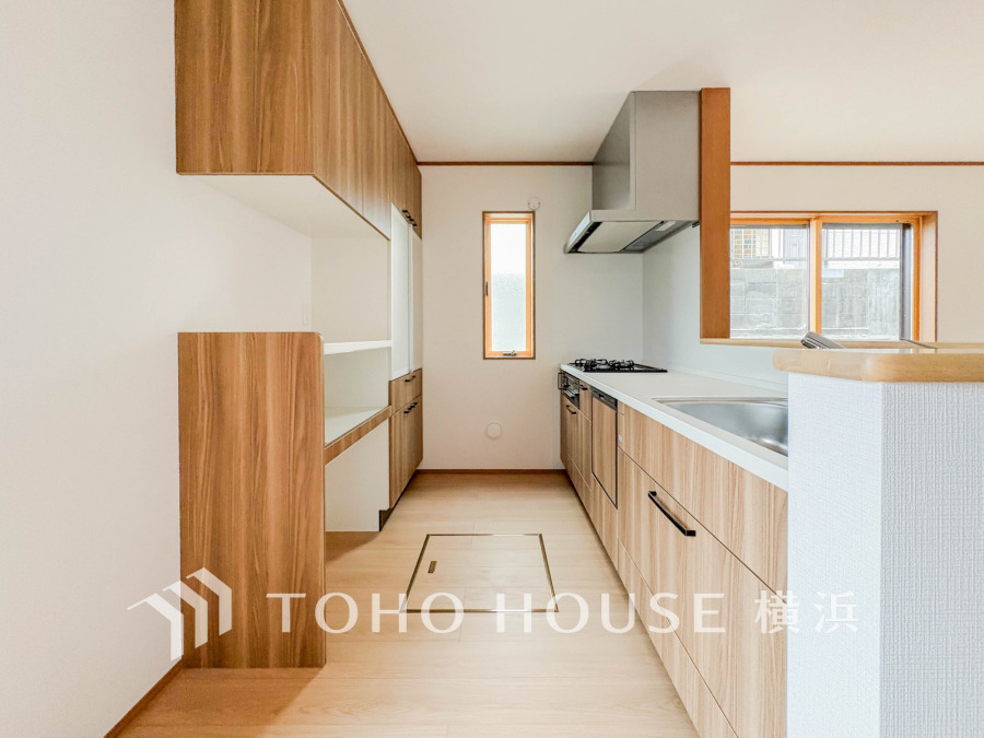 収納棚を背面に設置した統一感のあるキッチンスペースは美しく、機能性も良好です。
