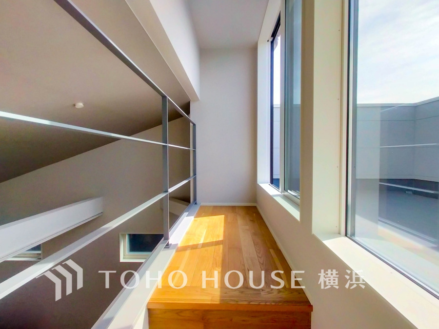 大きな窓から自然光が差し込む明るい空間。シンプルなデザインで開放感あふれる室内廊下です。