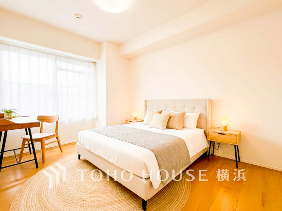 自然光が溢れる明るい寝室。シンプルで温かみのあるインテリアが心地よい安らぎの空間を演出します。