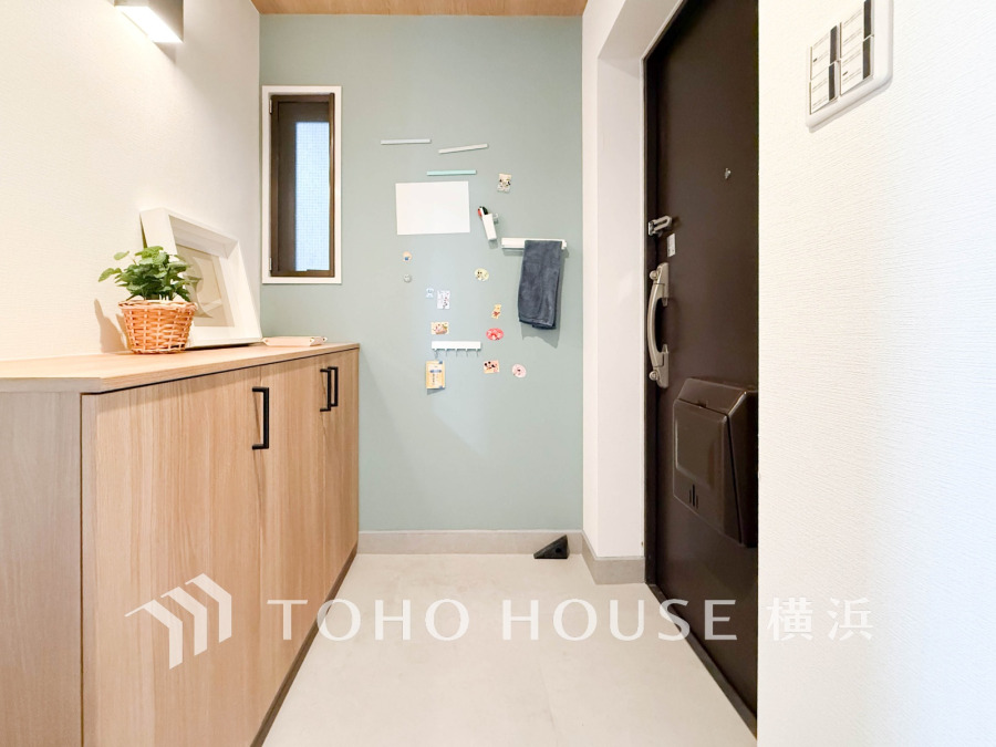 清潔感のある玄関は小窓とアクセントクロスが印象的な明るい空間です。