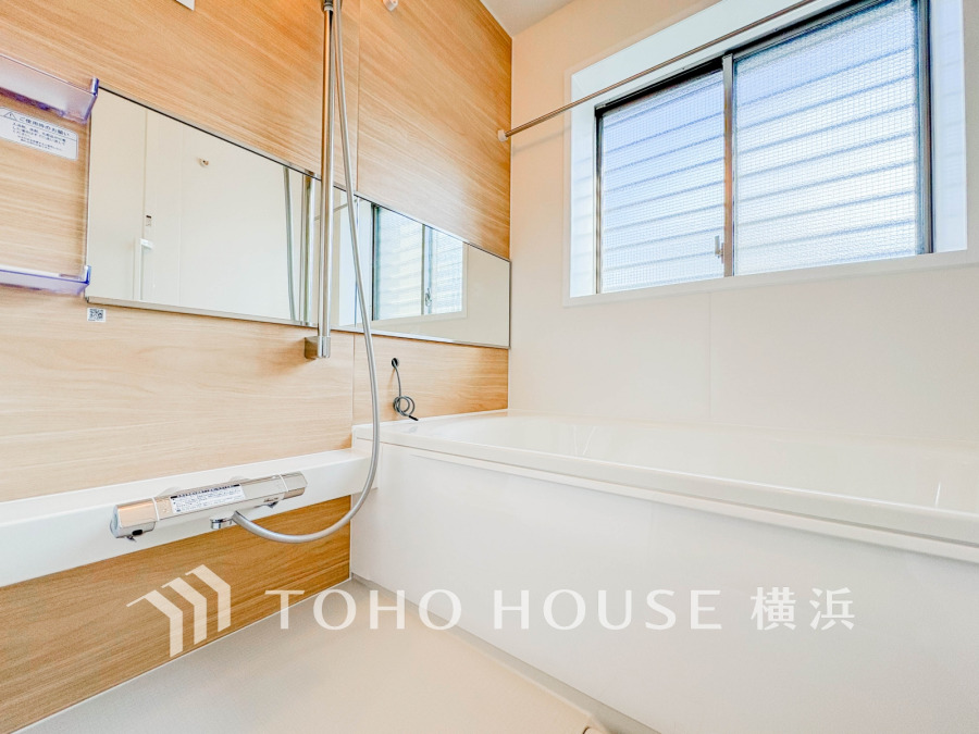 木目調パネルが温かみを演出するバスルーム。窓付きで明るく通風良好です。