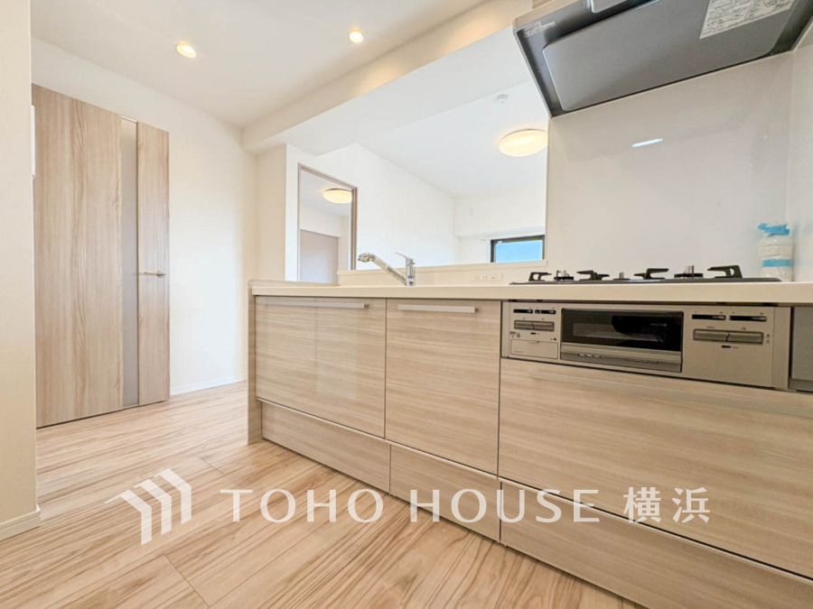 明るくナチュラルな色合いのシステムキッチン。使いやすさと収納力を兼ね備えた快適な調理空間です。