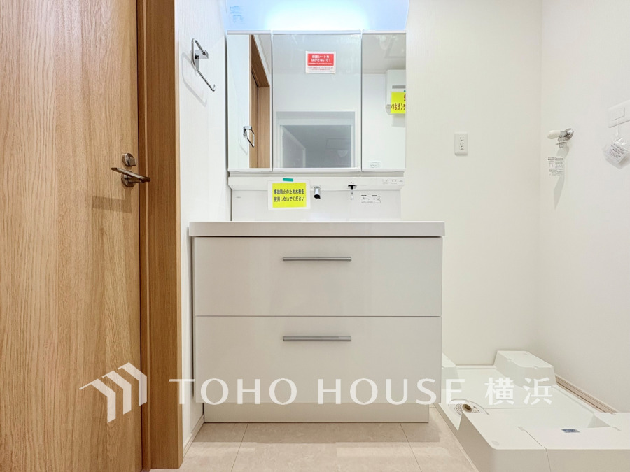 清潔感あふれるホワイト基調の洗面台と洗濯機置き場が一体となった機能的なサニタリースペースです。