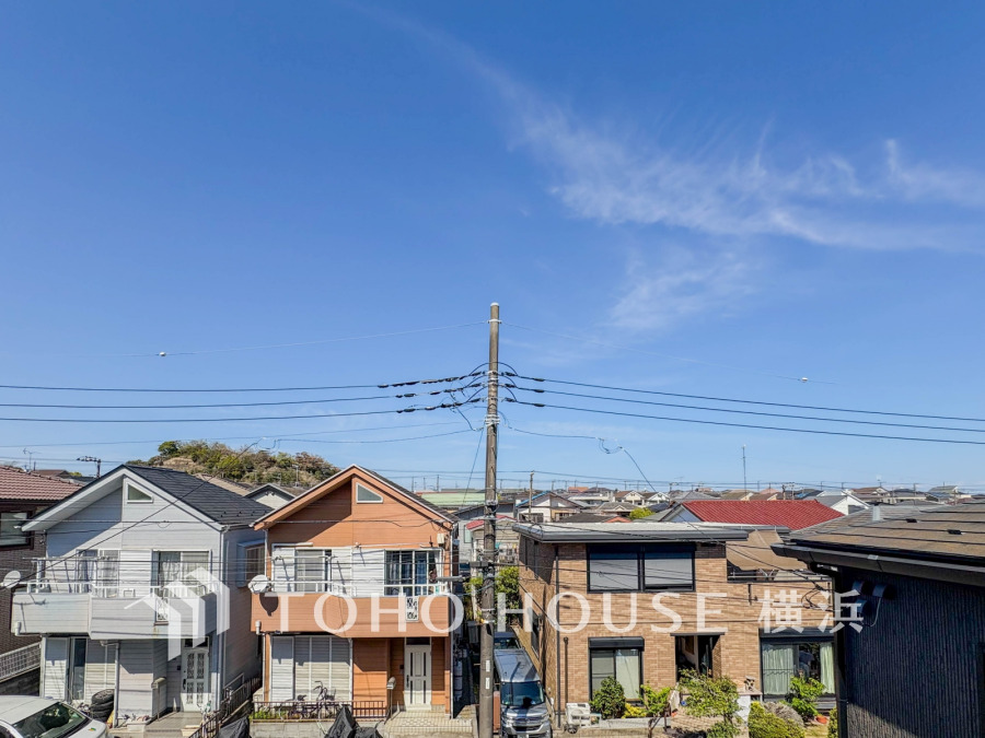 晴天の空の下、閑静な住宅街が広がる眺望。日当たり良好で快適な住環境が魅力です。