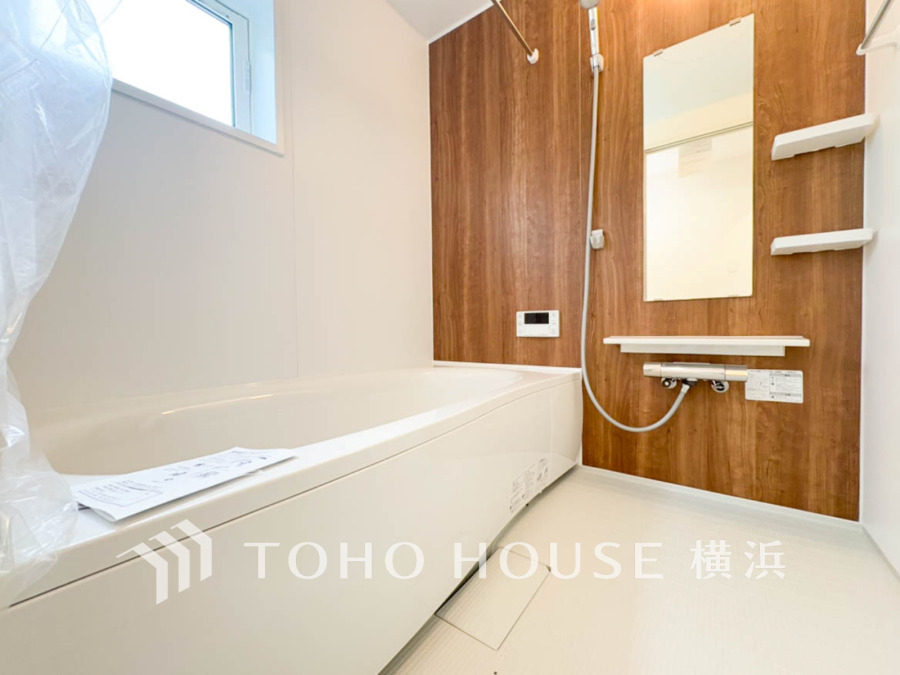 木目調のアクセントパネルが温かみを演出する、清潔感あふれるバスルームです。窓から自然光も取り込めます。