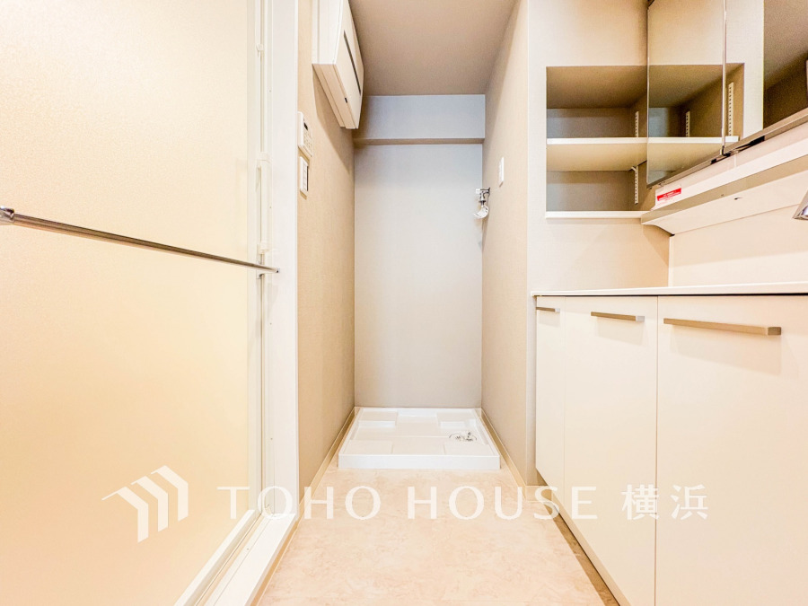 清潔感あふれる洗面所。収納豊富なキャビネットと洗濯機置き場が設けられ、快適な家事空間を実現します。