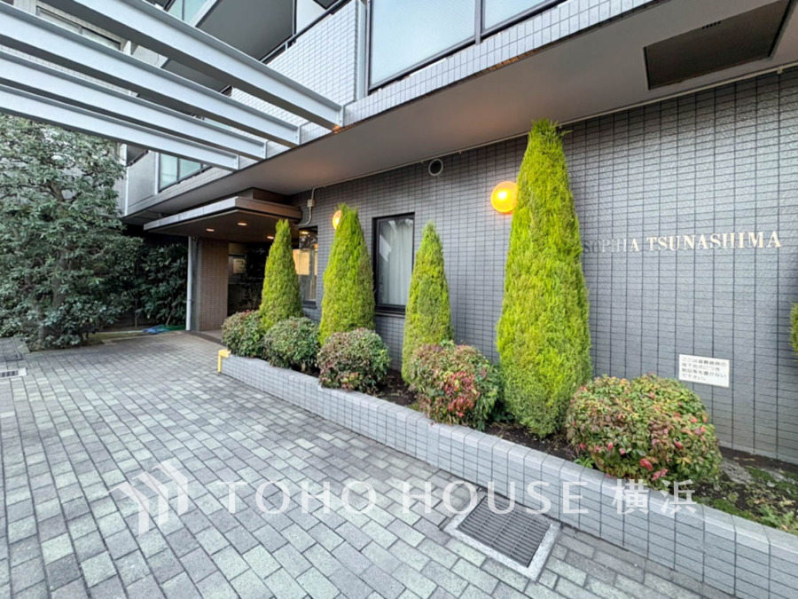 手入れの行き届いた植栽が迎える、落ち着いた雰囲気のマンションエントランスです。