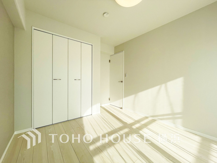 陽光が差し込む明るい室内。シンプルな白い収納扉とナチュラルなフローリングで清潔感あふれる空間です。