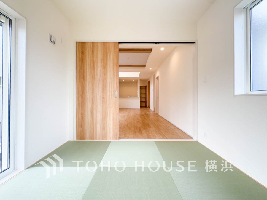 光が差し込む和室と木目調の引き戸が調和する、落ち着いた雰囲気の居住空間です。