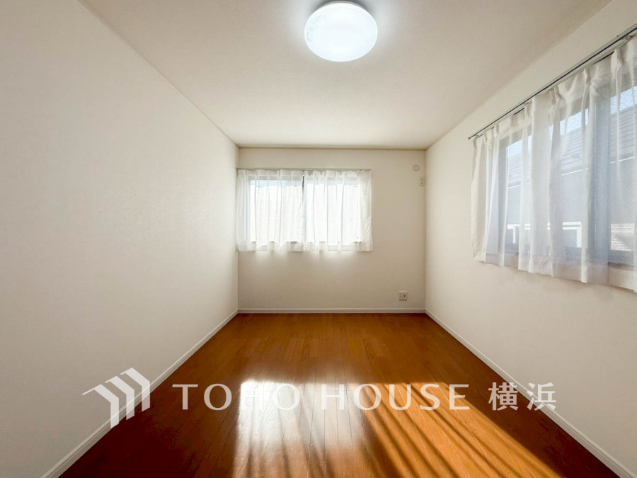 二面採光で明るく風通し良好な居室。シンプルな白壁と木目床が温かみのある空間を演出します。