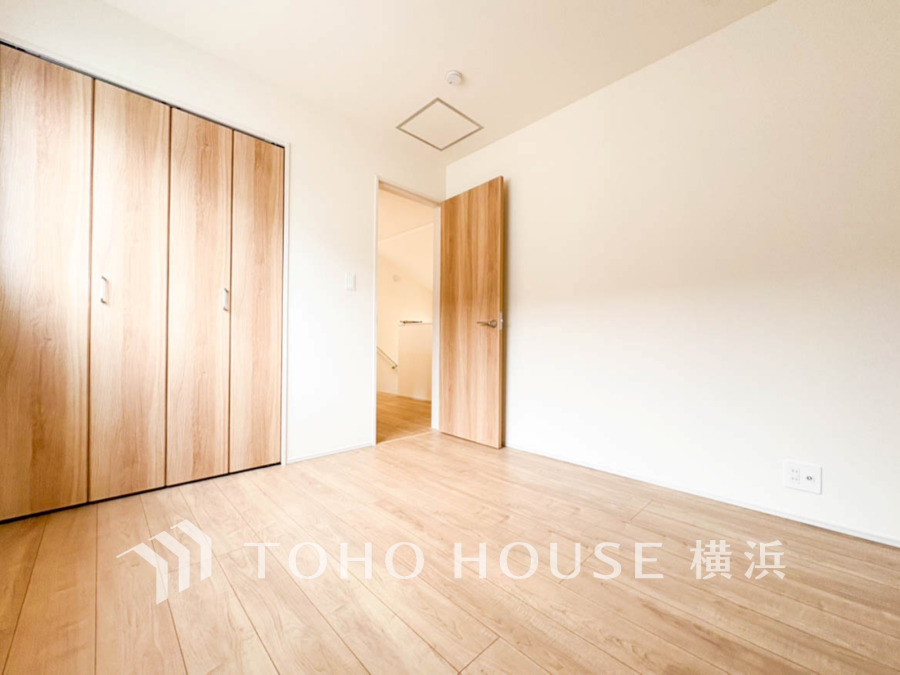 ナチュラルな木目調の床と扉が温かみを演出。広々としたクローゼット付きのシンプルで明るい居室です。