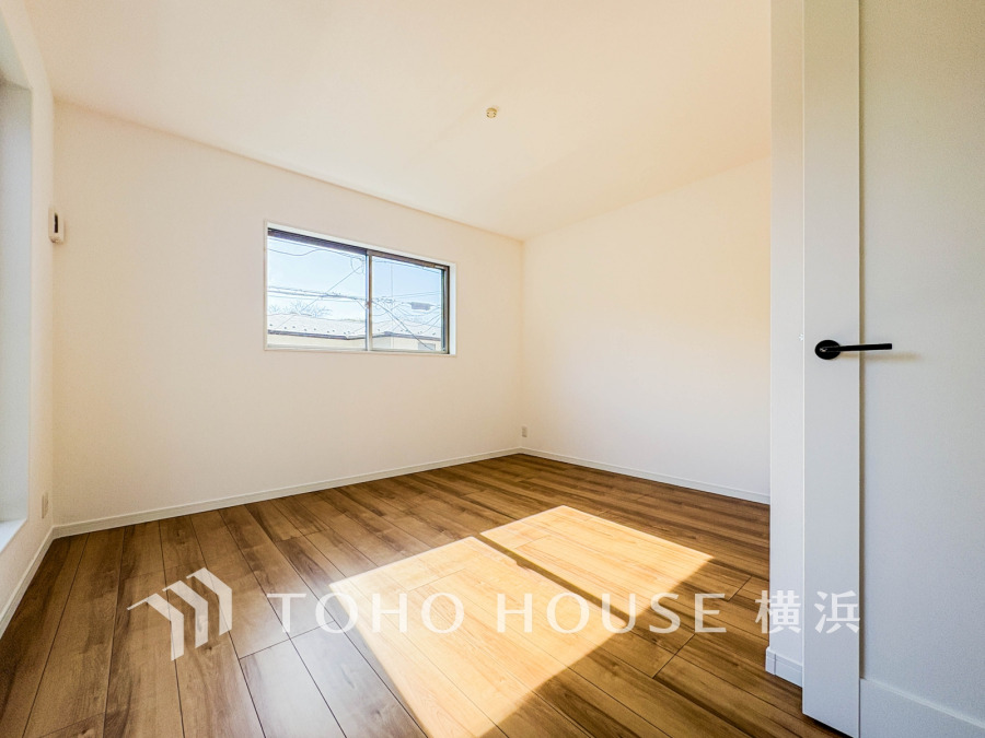 自然光がたっぷり入る明るい洋室。シンプルな白壁と木目調フローリングで温かみのある空間です。