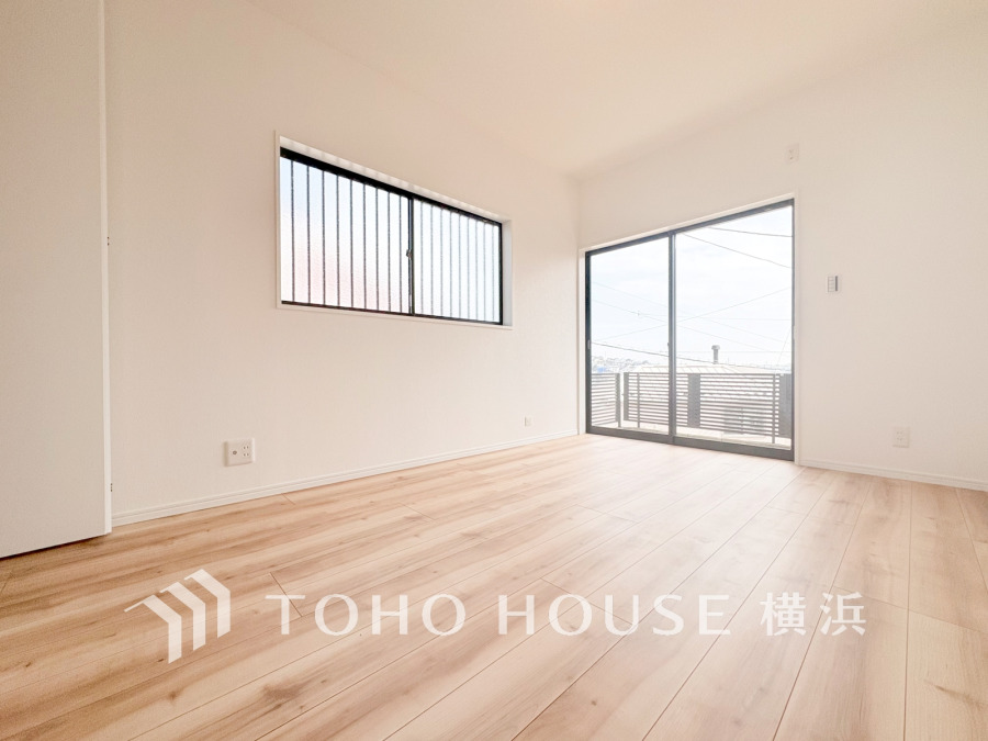 大きな窓からたっぷりの陽射しが注ぎ込む明るい洋室。
