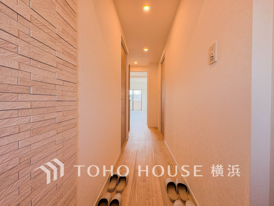 温かみのある照明と木目調の床が迎える、明るく清潔感あふれる廊下が、住まいの快適さを演出します。