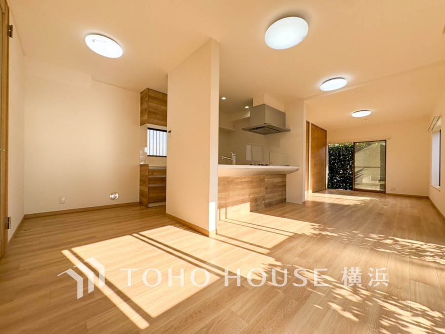 陽光が差し込む広々としたリビング・ダイニング。木目調のキッチンが温かみを演出します。