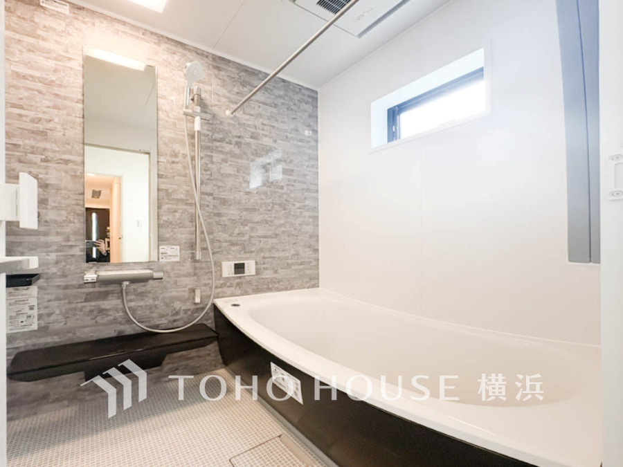 スタイリッシュなグレーの壁面と広々浴槽が魅力の、明るく清潔感あふれるユニットバスルームです。