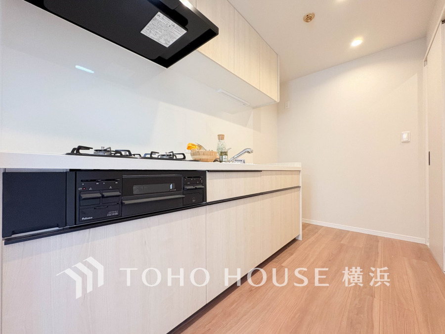 ナチュラルカラーで統一された清潔感あるキッチン。収納豊富で使い勝手の良いシステムキッチンです。