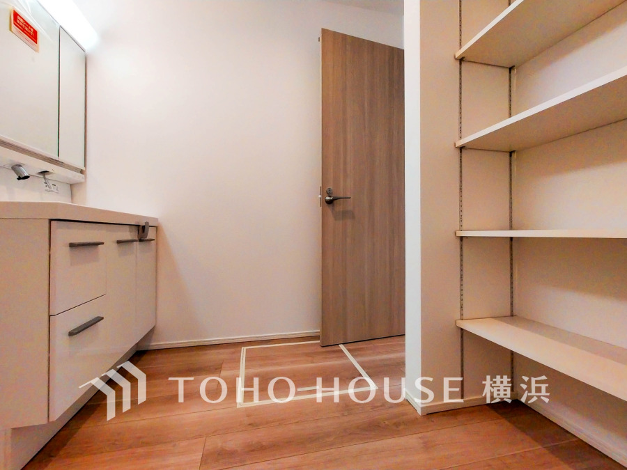 収納棚付きの洗面スペース。清潔感あるホワイトで使いやすさと収納力を両立した設計です。