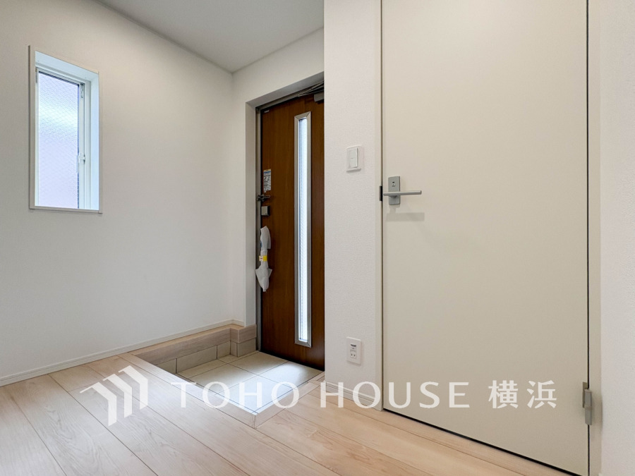 明るい自然光が差し込む、清潔感あふれる玄関スペース。シンプルで使いやすい設計です。