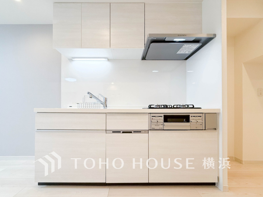 清潔感あふれるホワイト基調のシステムキッチン。収納豊富で使いやすさを追求した設計です。