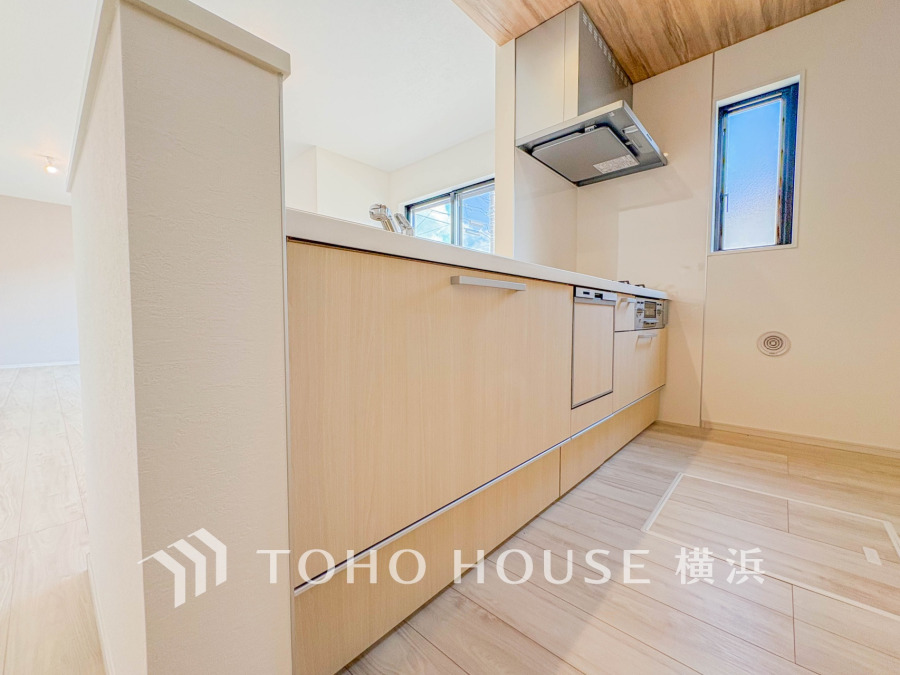 明るく開放的なキッチンは、木目調の収納が温かみを演出し、使いやすさと清潔感を兼ね備えています。