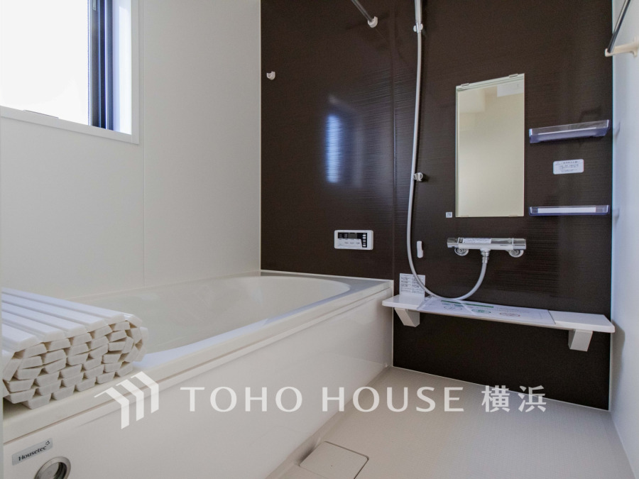 落ち着いたブラウンの壁面が印象的な、清潔感あふれるモダンなバスルームです。