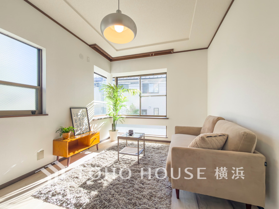 陽光が差し込む明るいリビング。シンプルで落ち着いたインテリアが寛ぎの空間を演出します。