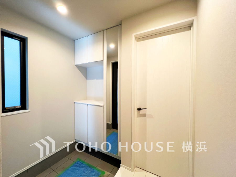 収納豊富な玄関スペース。白色を基調としていて、清潔感のある空間です。
