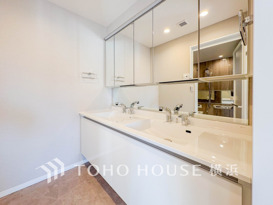 清潔感あふれるダブルシンクの洗面台。大きな鏡と収納で毎日の身支度も快適にサポートします。