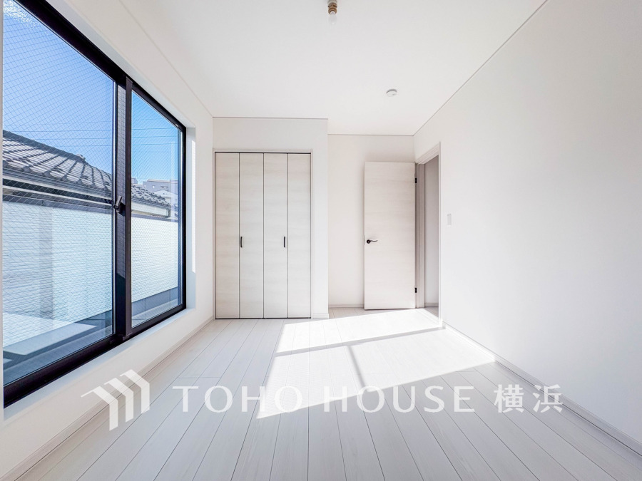 バルコニーから明るい自然光が差し込む洋室。大型クローゼット付きで収納も充実しています。
