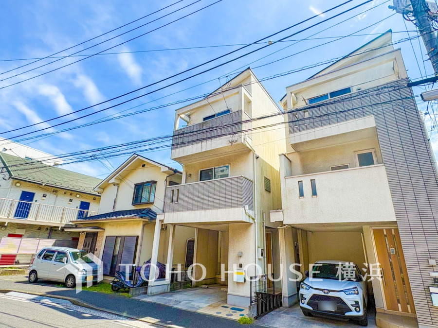 閑静な住宅街に立つ、駐車スペース付きの3階建てモダン住宅。明るい空と調和した外観が魅力です。