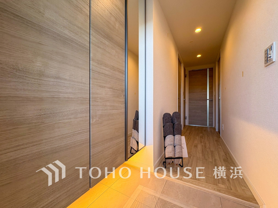 玄関は木目調の収納と間接照明で温かみのある空間を演出しています。