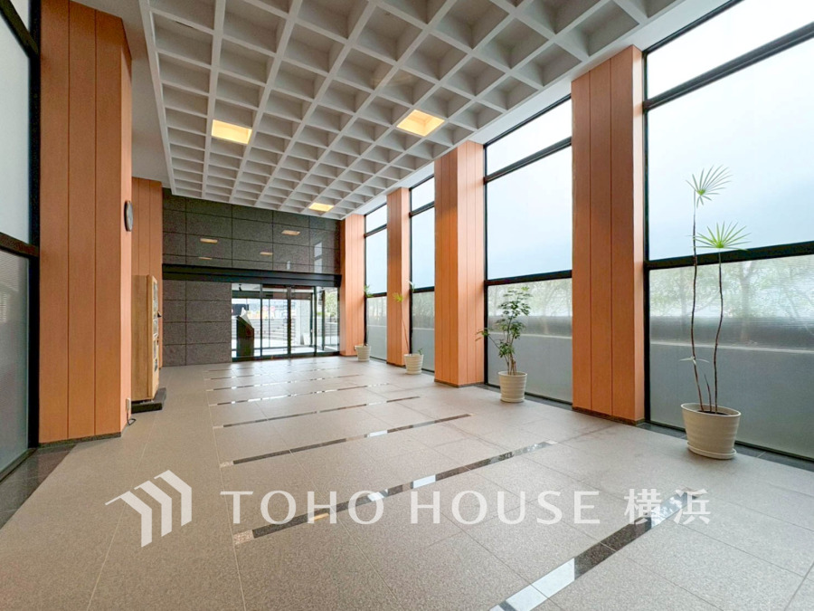 自然光が差し込む広々としたエントランスホール。高い天井と上品な木目調の柱が落ち着きを演出します。
