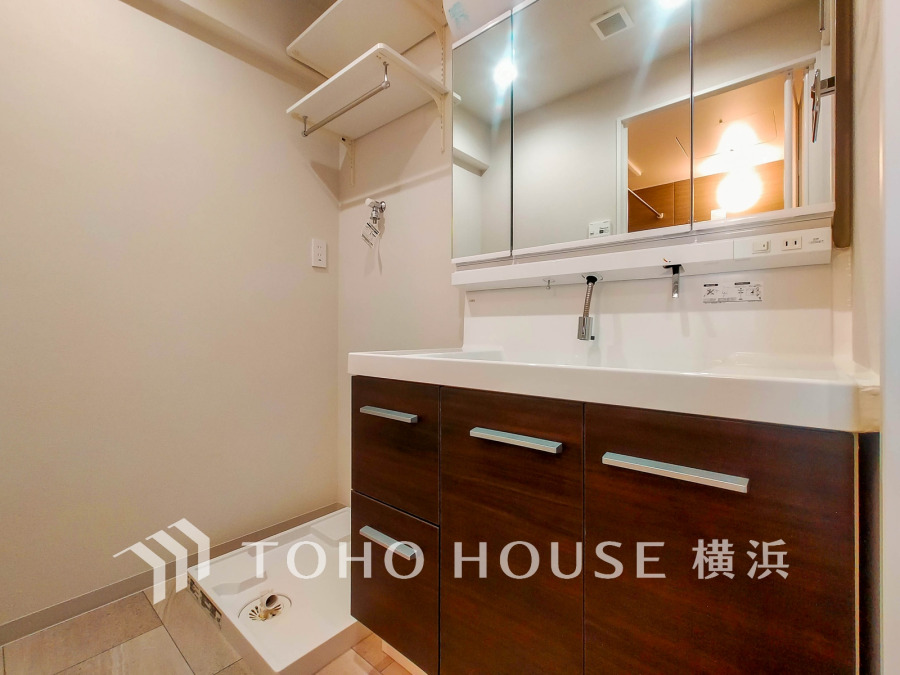 清潔感あふれる洗面台と洗濯機置き場を備えた機能的なサニタリースペースです。