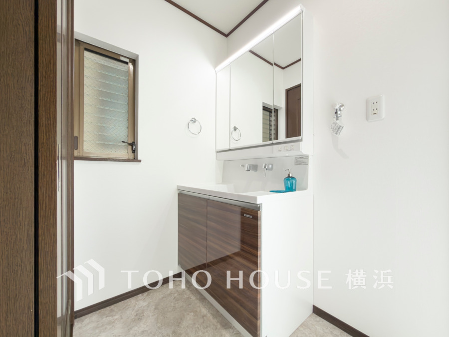 清潔感あふれる洗面スペース。収納力のある鏡裏収納と窓からの自然光で明るく快適な空間を実現しています。