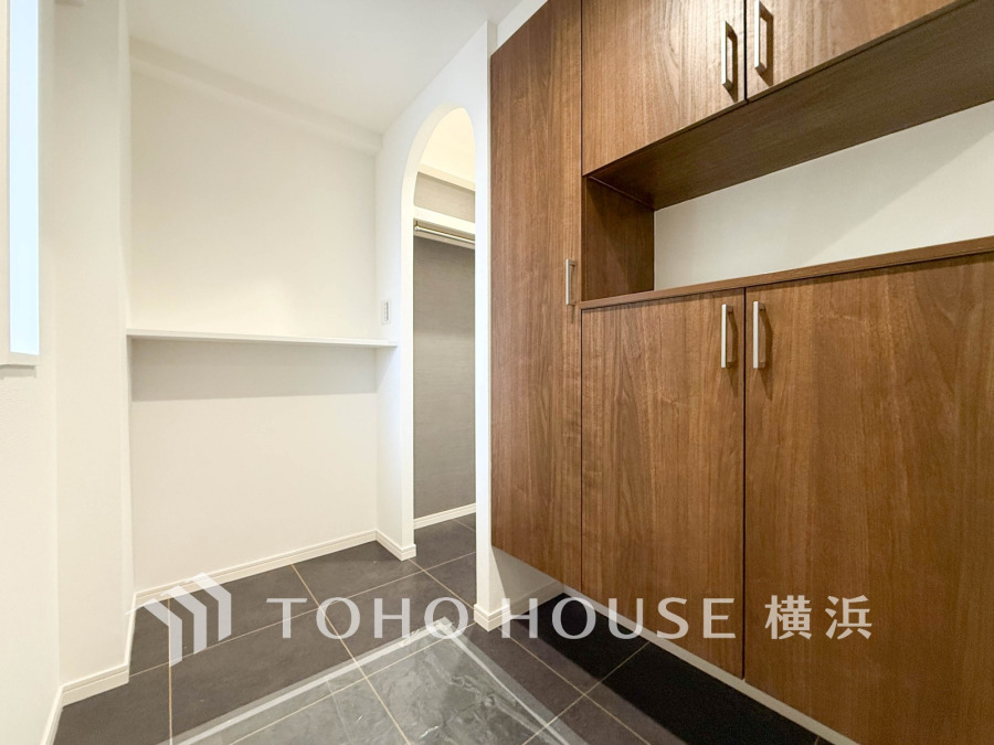 木目調の収納と大容量のSICを備えた玄関スペース。