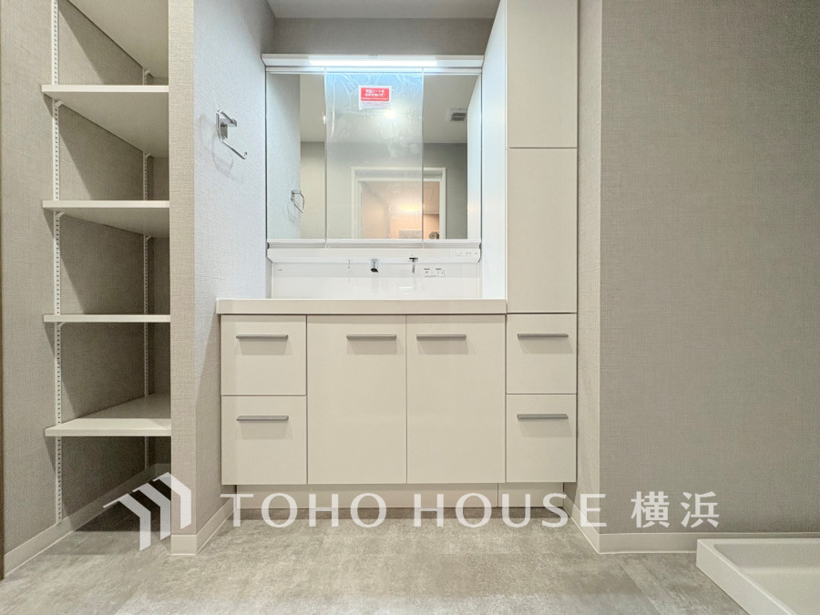 パウダールームは、ホワイトを基調とした明るく清潔感溢れる空間。リネン類や洗剤などを収納できる棚も設置し、美しさと暮らしやすさの両面を揃えました。