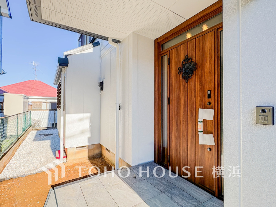 木目調の玄関ドアが印象的な、明るく清潔感のあるエントランススペースです。風通しも良好です。