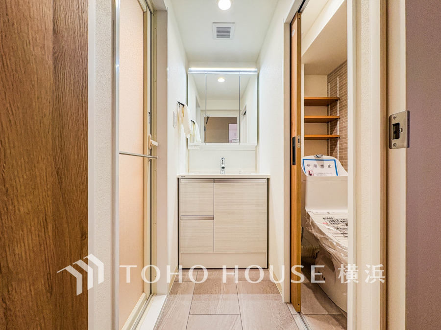 清潔感あふれる洗面スペース。収納豊富で使いやすく、隣接の洗濯機置き場も便利な設計です。