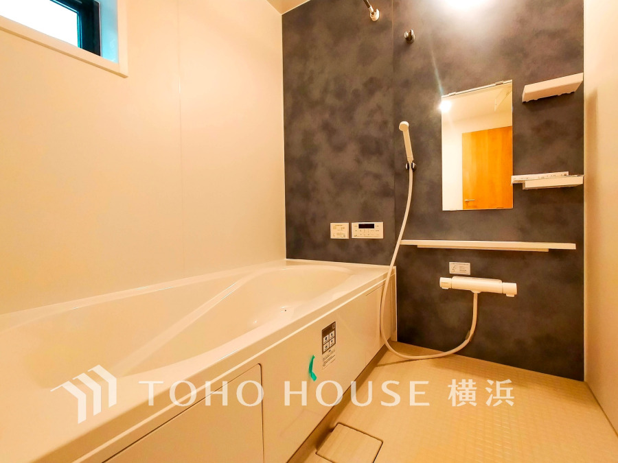 落ち着いたダークカラーの壁と白を基調とした清潔感あふれるバスルームで、快適なバスタイムを実現します。