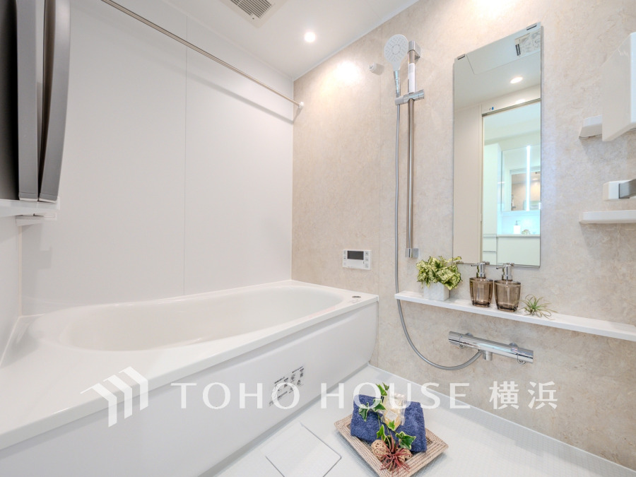 清潔感あふれる白基調のバスルーム。ゆったり浸かれる浴槽と便利なシャワー付きで快適なバスタイムを実現。