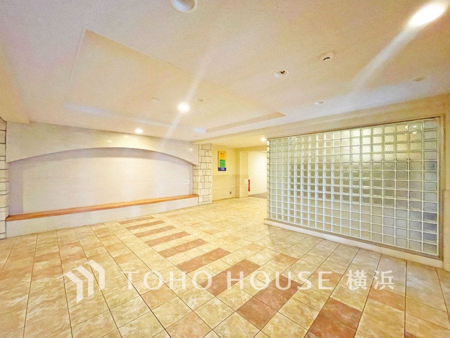 広々としたタイル張りのエントランスホール。ガラスブロックが柔らかな光を演出します。