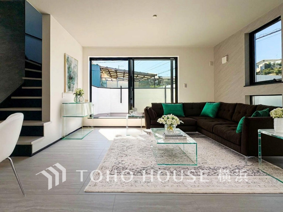 リビング階段採用で自然と家族がリビングに集まります。お子様がお出かけの際も必ずリビングを通ることになるので、コミュニケーションもしやすいですね。（家具・調度品はAIによるイメージです）