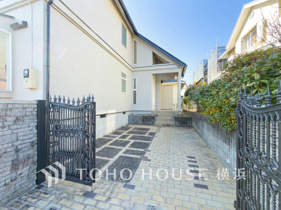 美しい門扉と植栽で彩られた広々としたアプローチと１台分のカースペース。