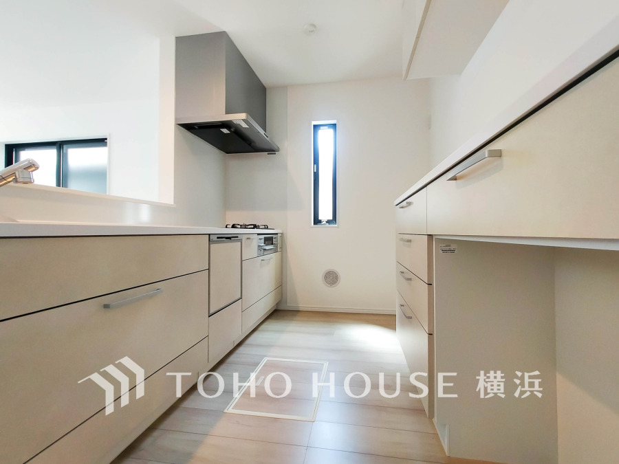 収納棚を背面に設置した統一感のあるキッチンスペースは美しく、機能性も良好です。
